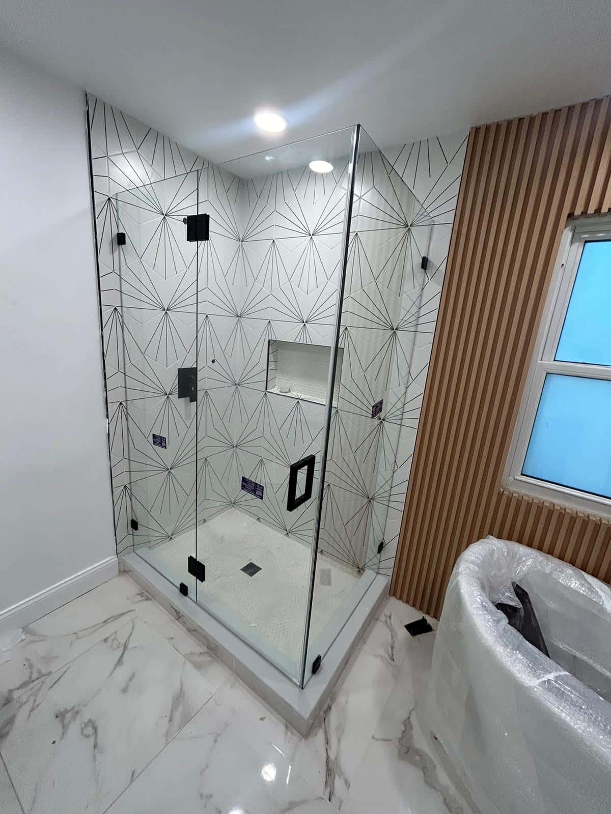 Modern Bathroom with Geometric Tile Design and Glass Shower Enclosure